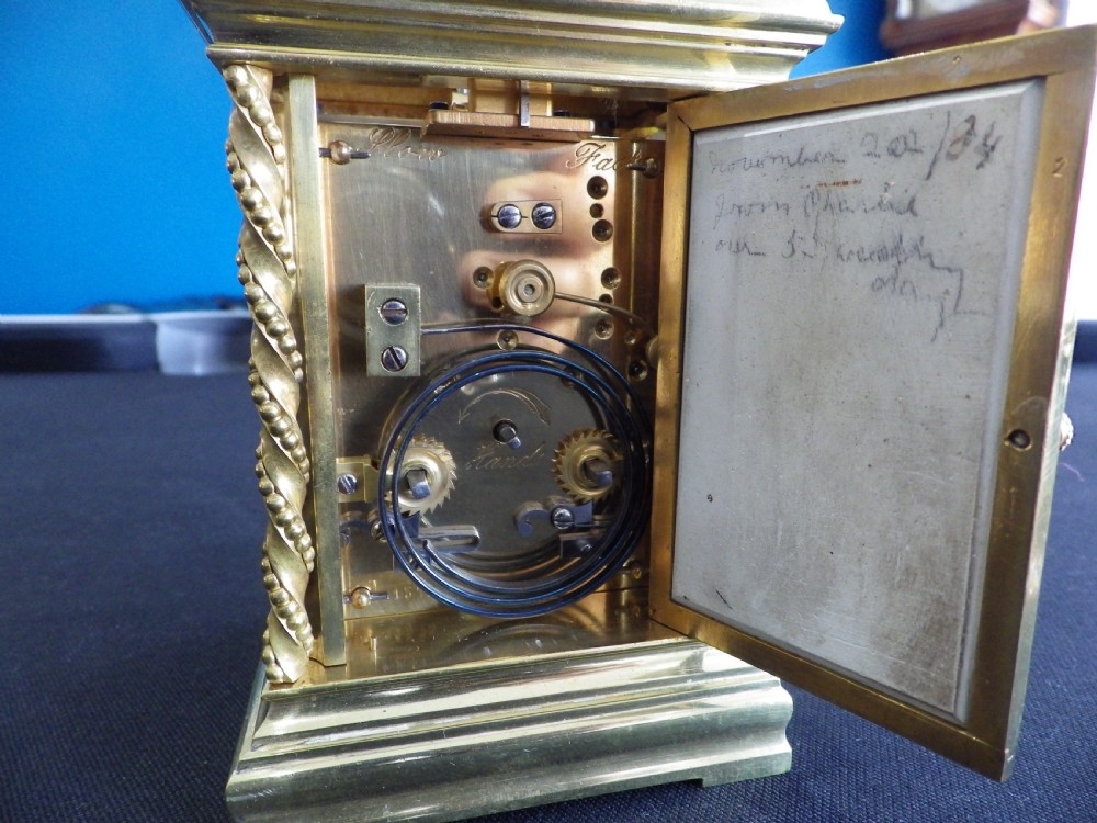 A late 19th-century French gilt brass repeating carriage clock featuring rope-twist columns and a light blue enamel dial panel decorated with painted birds and floral motifs. View V