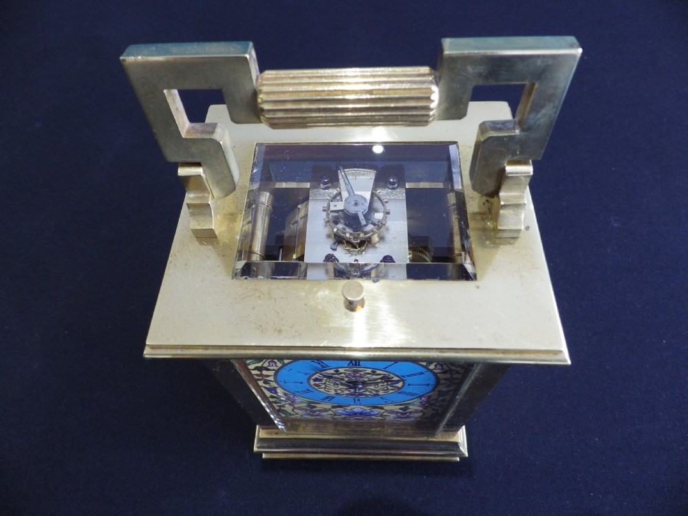 A late 19th-century French carriage clock featuring a rectangular brass frame, a top carrying handle, and a polychrome floral enamel face with Roman numerals. View V