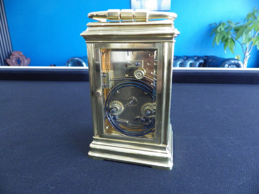 A restored 19th-century French repeater carriage clock featuring a polished brass case with clear glass panels, a top handle, and a white enamel dial with black Roman numerals. View III