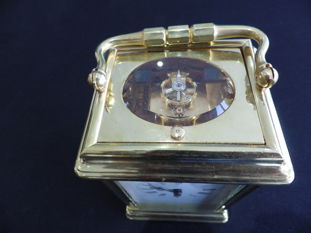A restored 19th-century French repeater carriage clock featuring a polished brass case with clear glass panels, a top handle, and a white enamel dial with black Roman numerals. View V