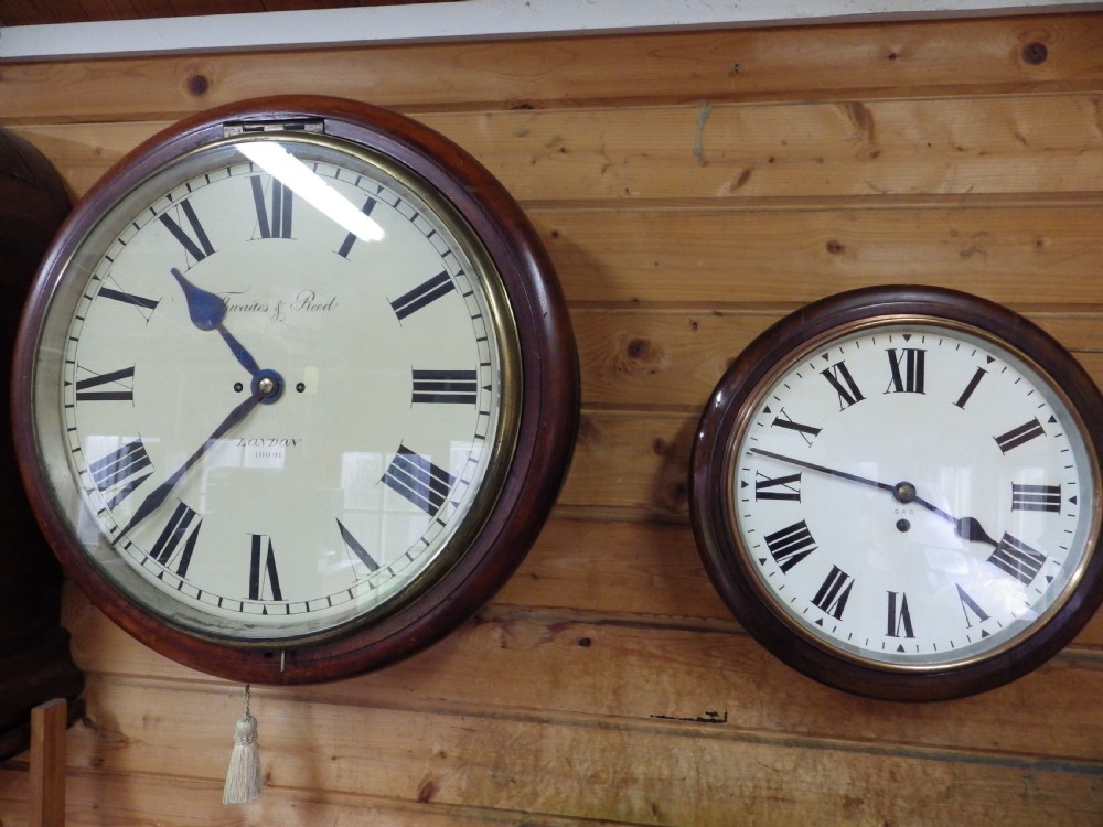 An antique circular mahogany wall clock featuring an eighteen-inch off-white dial with black Roman numerals, black spade hands, and a brass bezel. View VIII