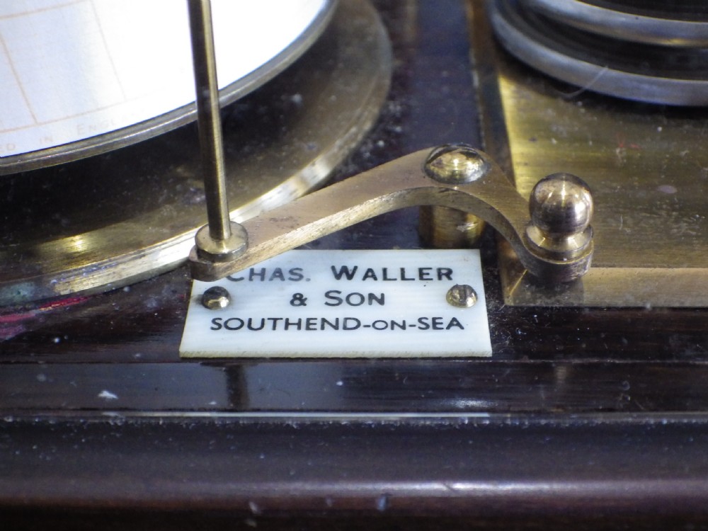 A 1920s mahogany and glass barograph featuring brass internal mechanisms, an aneroid capsule stack, and an engraved brass presentation plaque on the drawer base. View IV