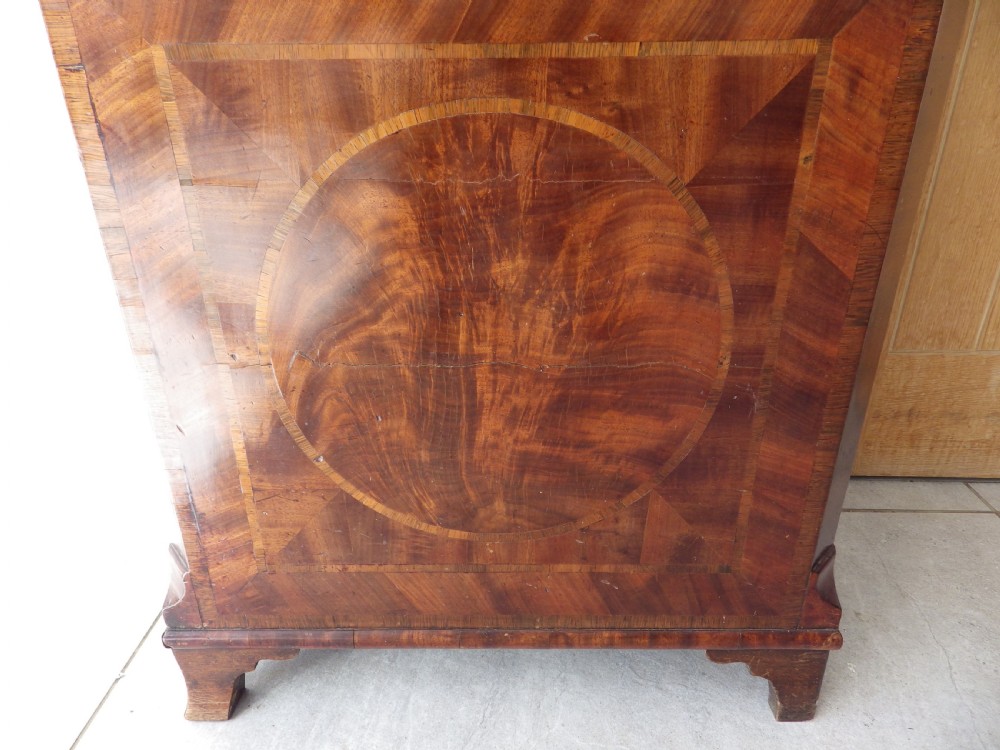 An antique flame mahogany longcase clock featuring a painted dial, swan-neck pediment with brass finials, and spirally turned column detailing. View VIII
