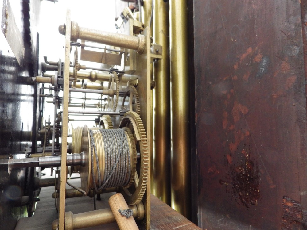 An antique flame mahogany longcase clock featuring a painted dial, swan-neck pediment with brass finials, and spirally turned column detailing. View XI