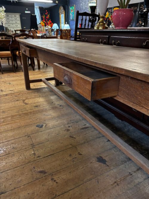 fig 2. An exceptionally long rustic solid oak serving table featuring dual apron drawers, square legs, and a low central stretcher.