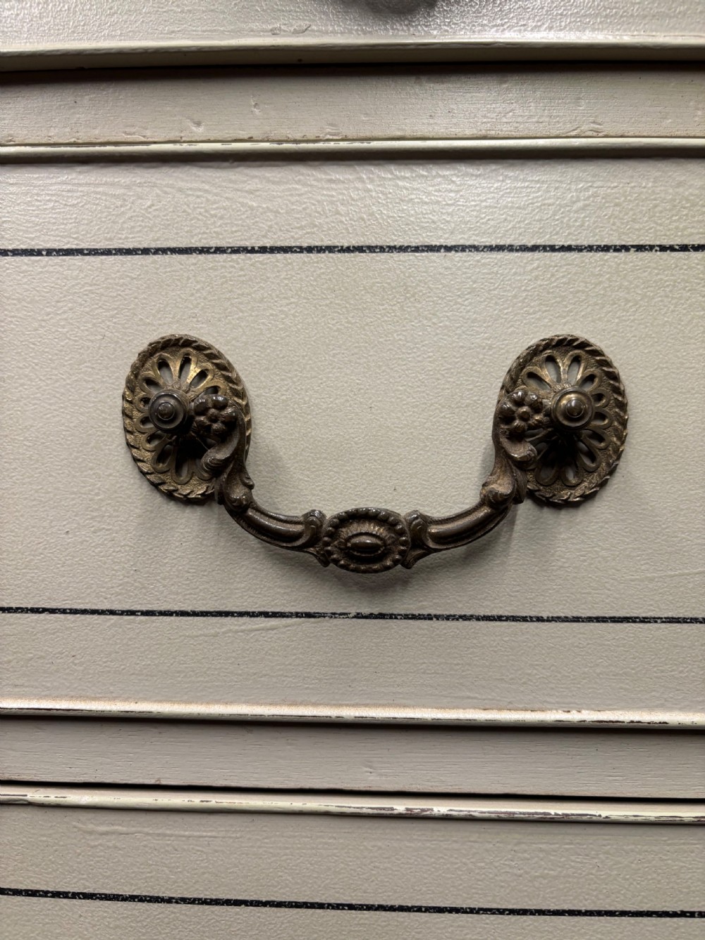 A tall cream-painted Georgian chest-on-chest featuring brass swan-neck handles, dentil moulding cornice, blue line detailing, and bracket feet. View X