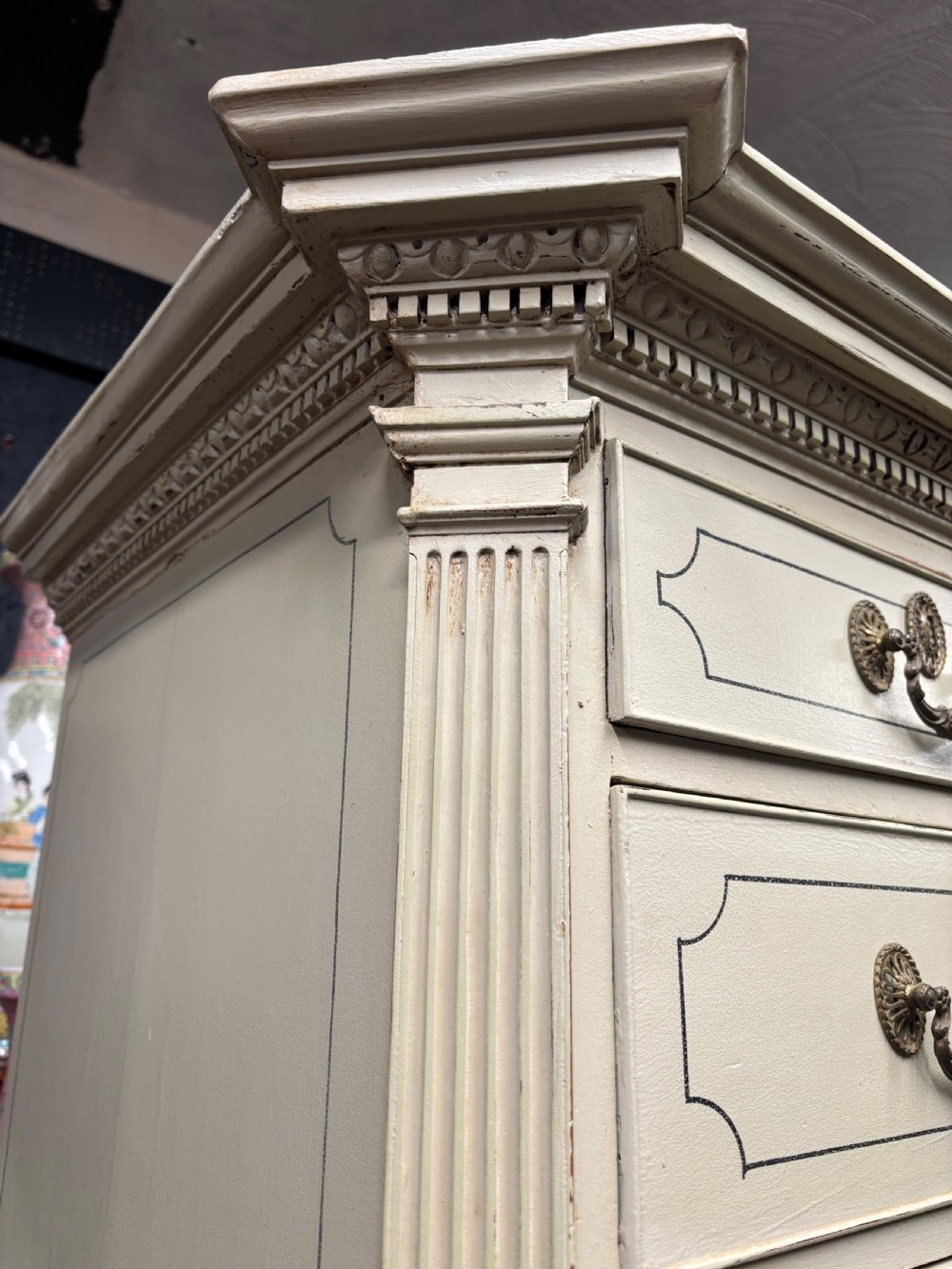 A tall cream-painted Georgian chest-on-chest featuring brass swan-neck handles, dentil moulding cornice, blue line detailing, and bracket feet. View XI