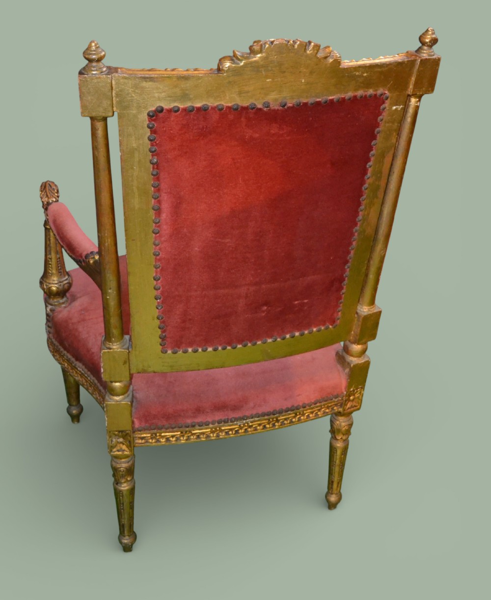 A pair of French giltwood armchairs featuring carved gold leaf frames, button-tufted red velvet backrests, padded armrests, and fluted turned legs. View III