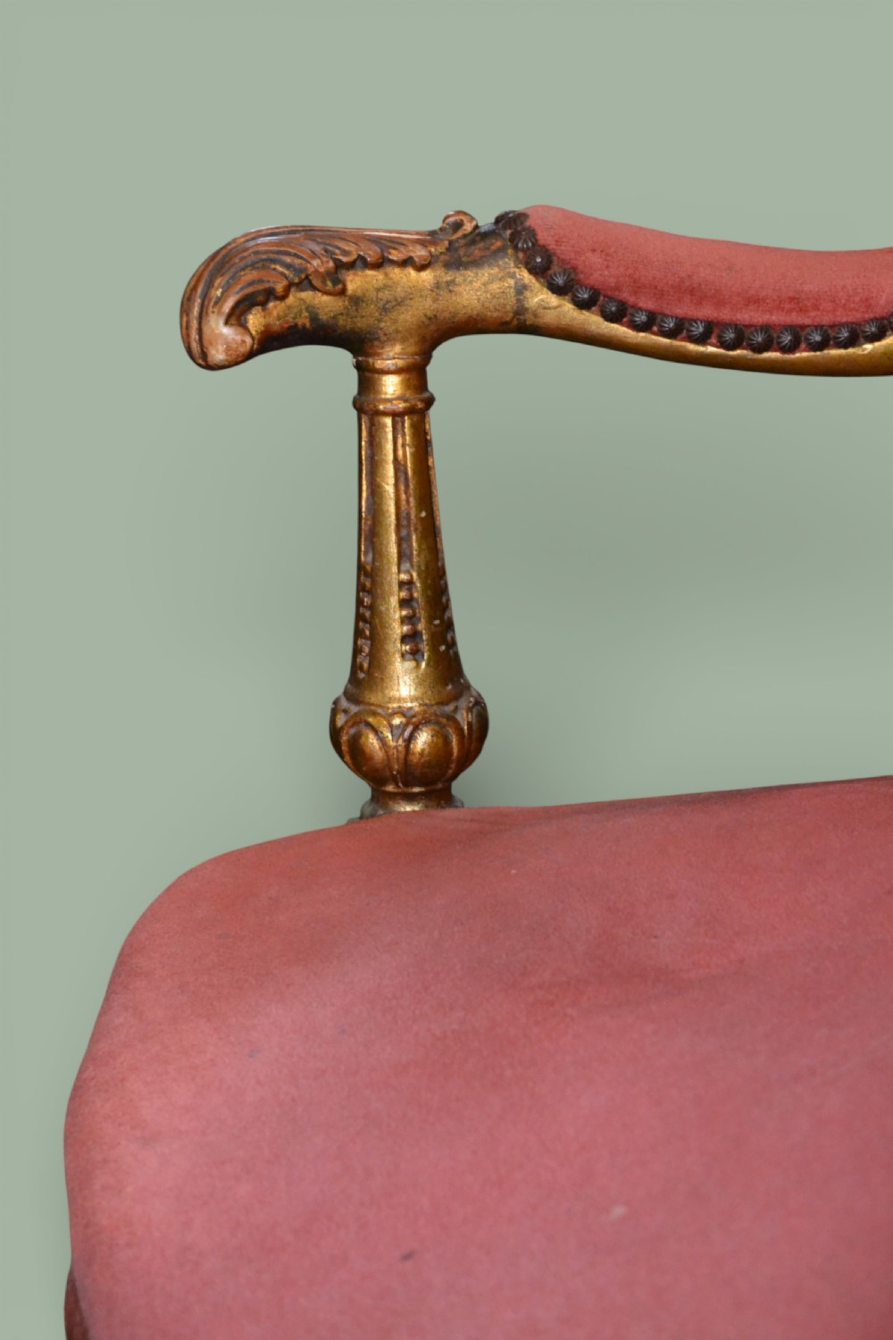 A pair of French giltwood armchairs featuring carved gold leaf frames, button-tufted red velvet backrests, padded armrests, and fluted turned legs. View IV