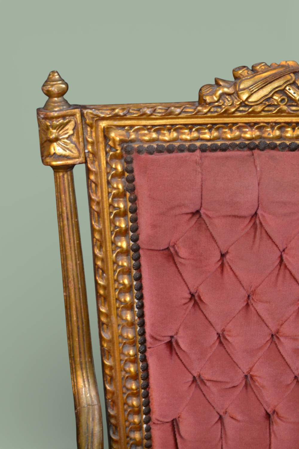 A pair of French giltwood armchairs featuring carved gold leaf frames, button-tufted red velvet backrests, padded armrests, and fluted turned legs. View VIII