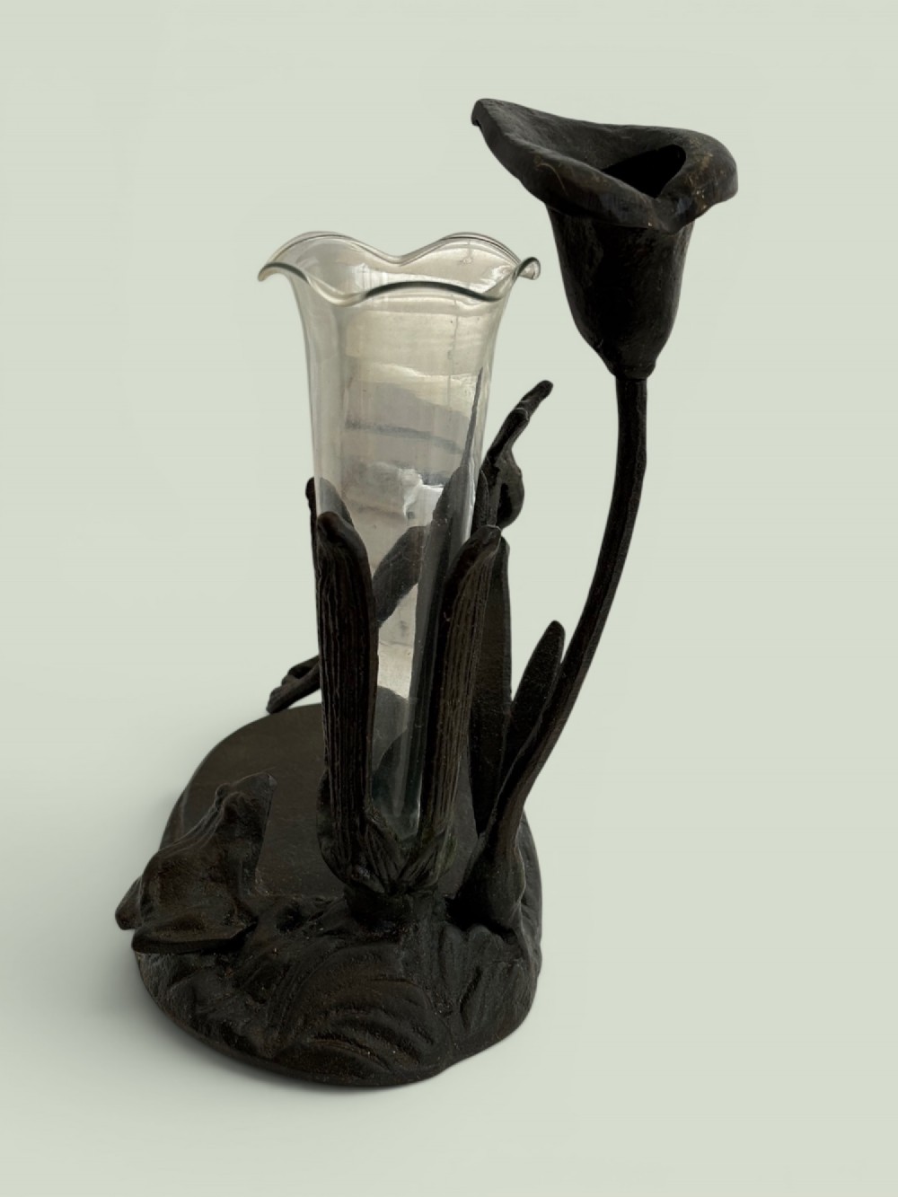 A dark patinated bronze Art Nouveau flower holder featuring sculpted frogs around a lily stem with a clear fluted glass vase liner. View VII