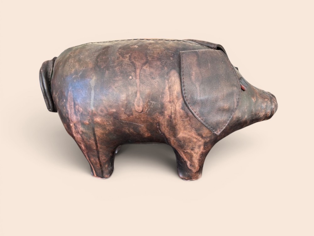 A handcrafted dark brown leather footstool shaped in the form of a pig with stitched panel detailing. View VI