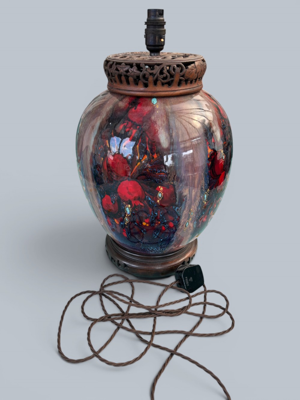 A baluster-shaped Moorcroft art pottery table lamp featuring hand-painted red fruit motifs, high-gloss glaze, and carved wooden mounts. View II