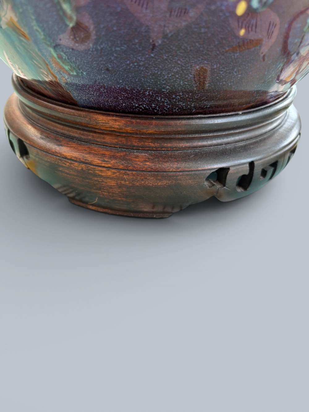 A baluster-shaped Moorcroft art pottery table lamp featuring hand-painted red fruit motifs, high-gloss glaze, and carved wooden mounts. View V