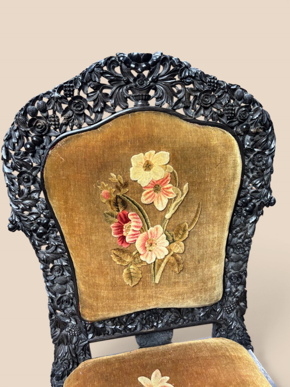 Late 19th-century Anglo-Indian ebony side chair featuring intricate hand-carved floral backrest detailing and floral needlepoint velvet seat. View V