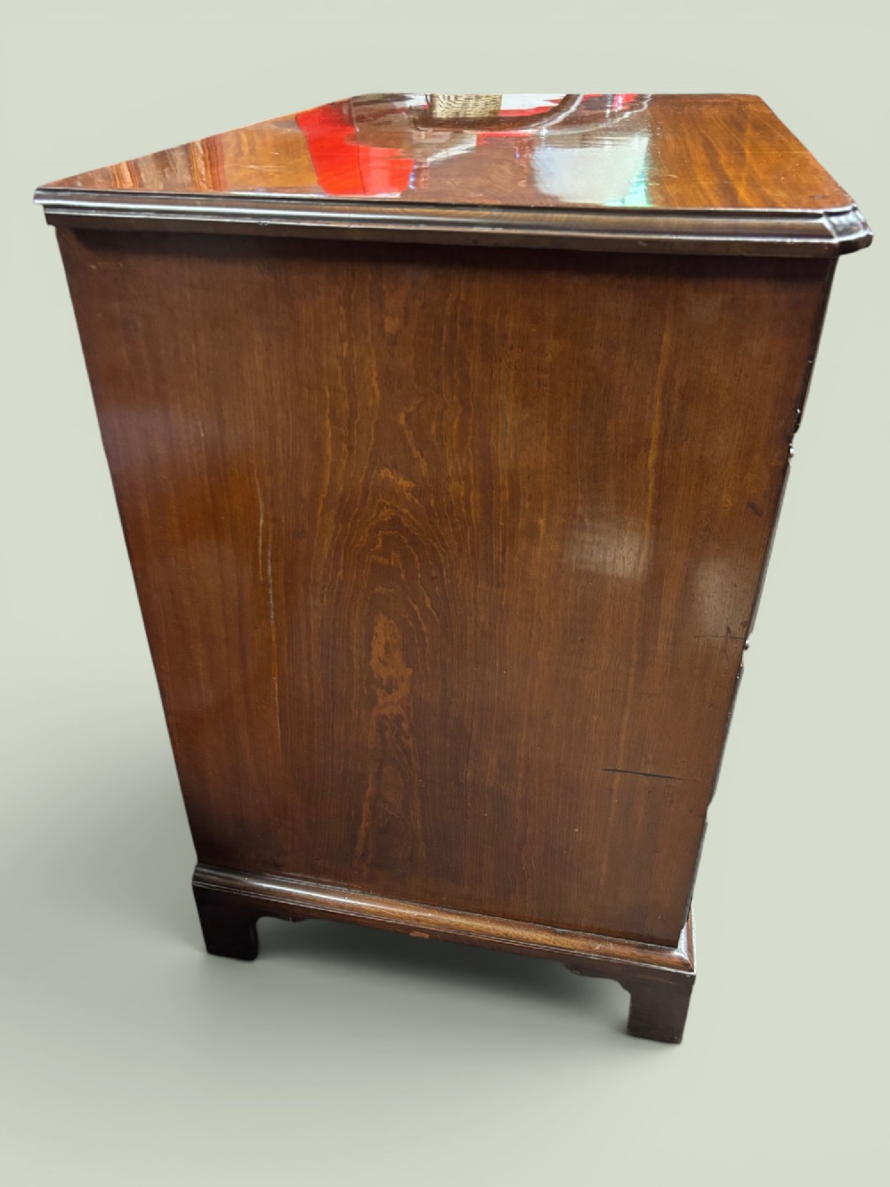 A Georgian mahogany kneehole desk with multiple drawers, brass swan-neck handles, a central recessed cupboard, and bracket feet. View II