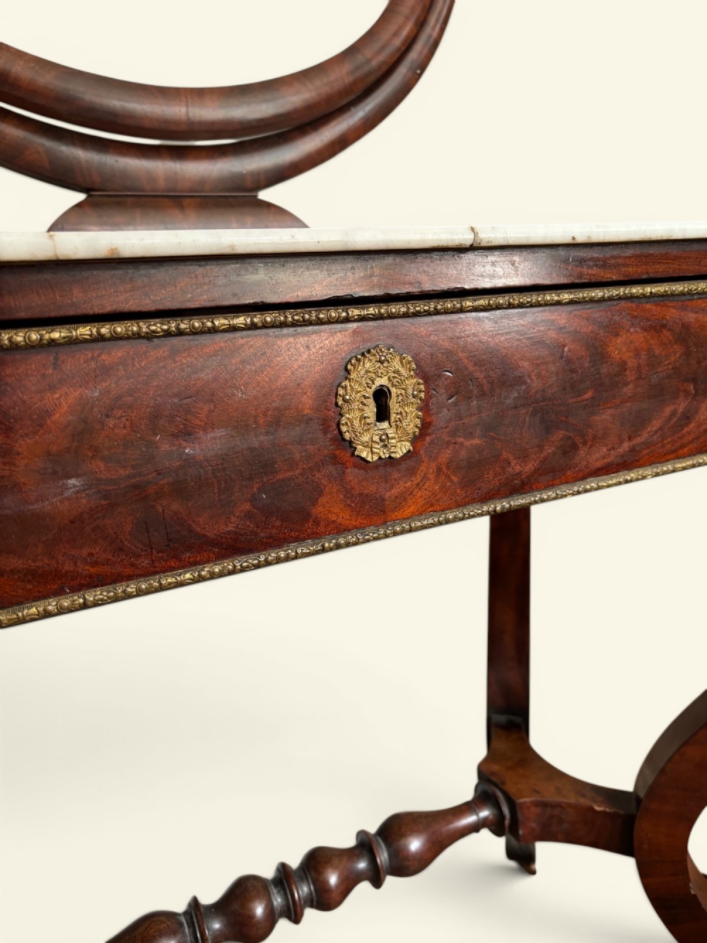 An antique dark wood dressing table featuring a swivel oval mirror, a white marble surface, S-curved legs on casters, and a central drawer. View III