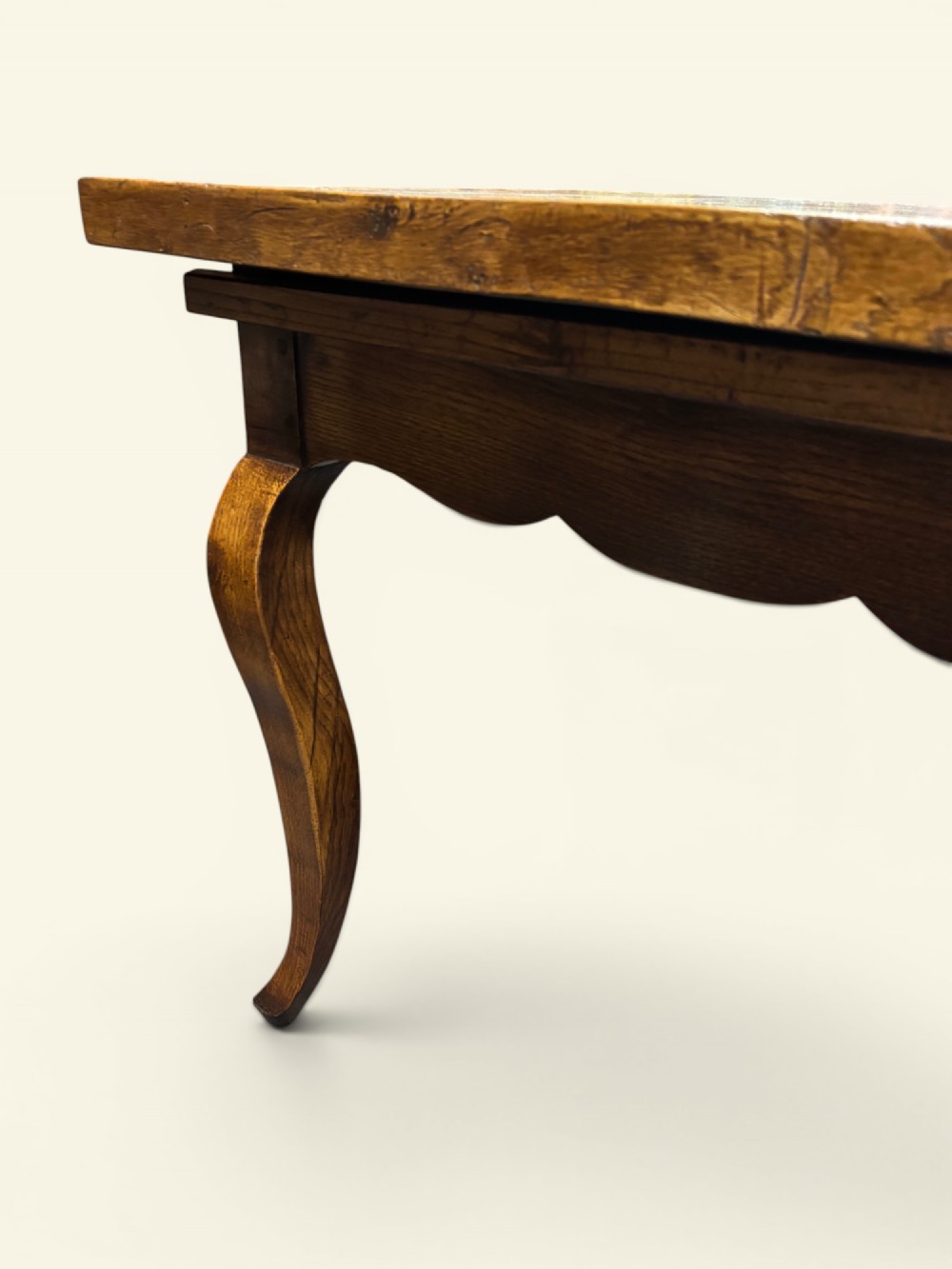A long French farmhouse fruitwood dining table featuring curved cabriole legs, a scalloped apron, and an end drawer with an iron pull handle. View II