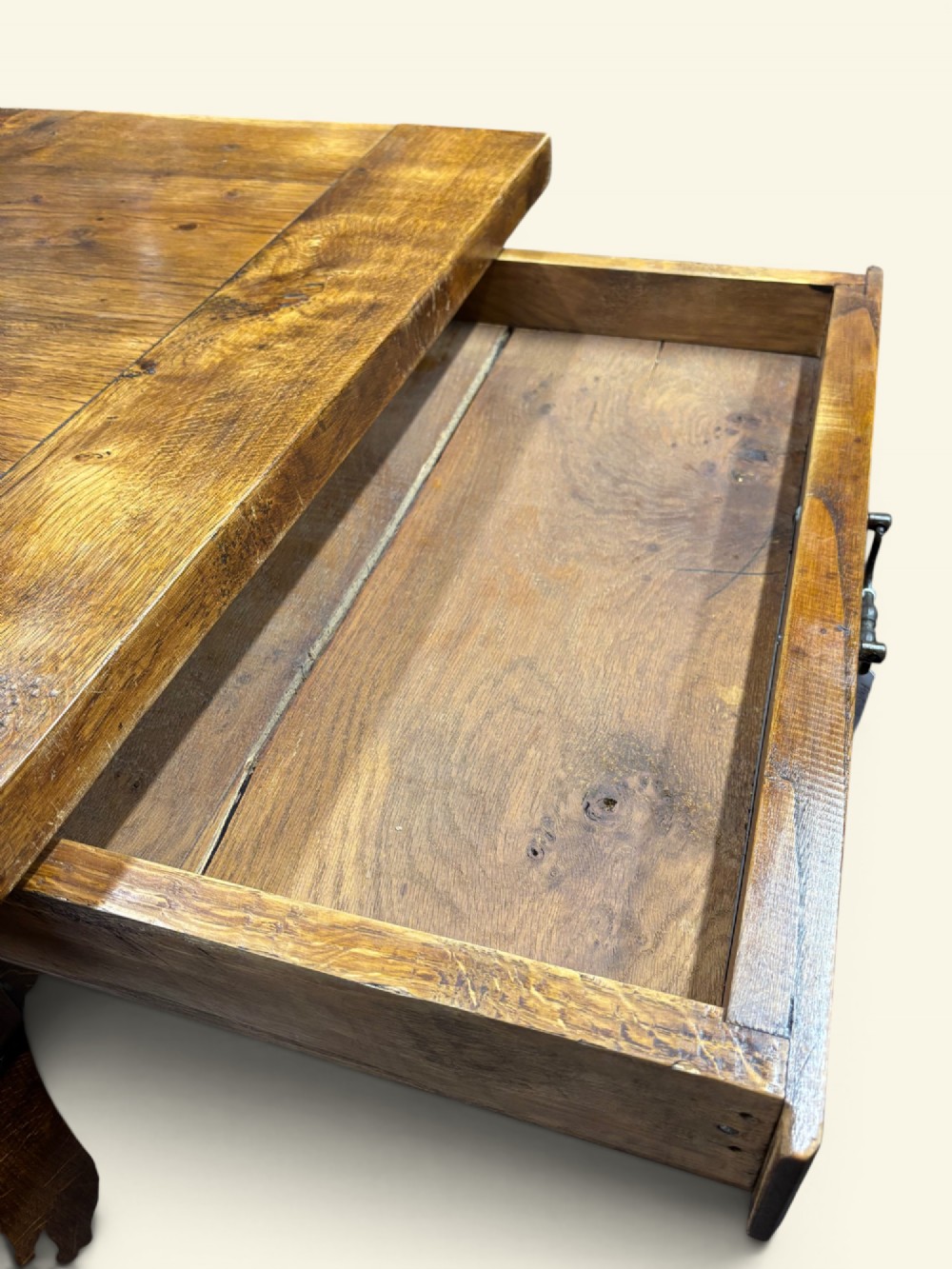 A long French farmhouse fruitwood dining table featuring curved cabriole legs, a scalloped apron, and an end drawer with an iron pull handle. View III