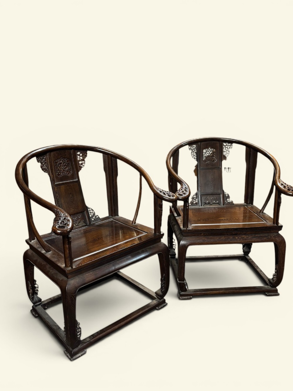 A pair of late Qing Dynasty Chinese dark hardwood horseshoe-back armchairs featuring carved back splats, sweeping crest rails, and rectangular panel seats. View II
