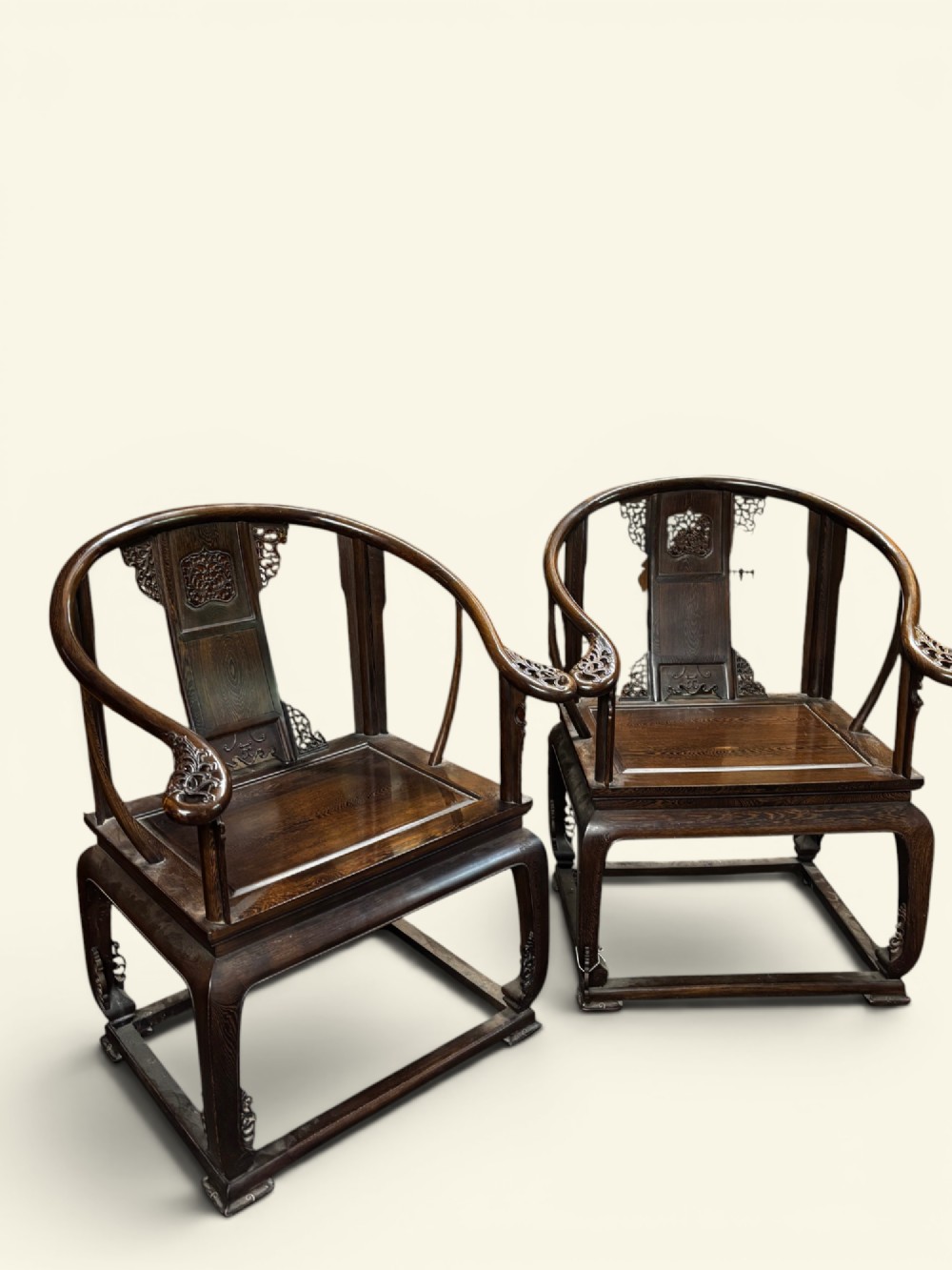 A pair of late Qing Dynasty Chinese dark hardwood horseshoe-back armchairs featuring carved back splats, sweeping crest rails, and rectangular panel seats. View IV