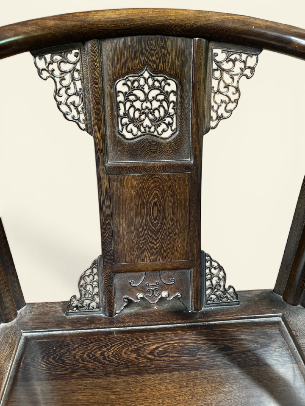 A pair of late Qing Dynasty Chinese dark hardwood horseshoe-back armchairs featuring carved back splats, sweeping crest rails, and rectangular panel seats. View V