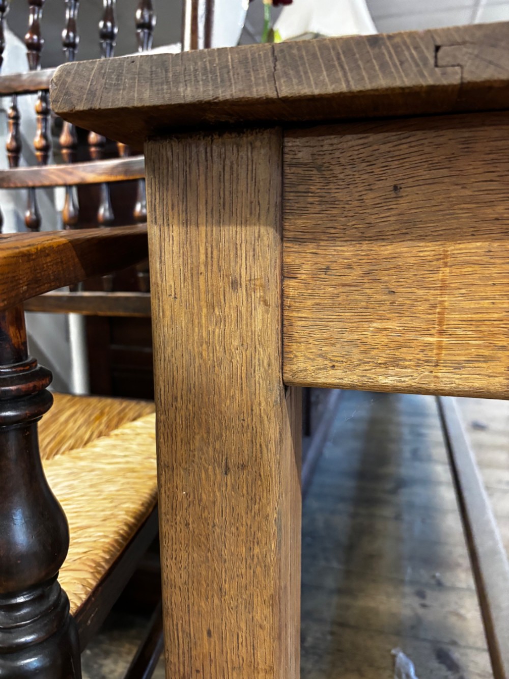 An exceptionally long rustic solid oak serving table featuring dual apron drawers, square legs, and a low central stretcher. View IV