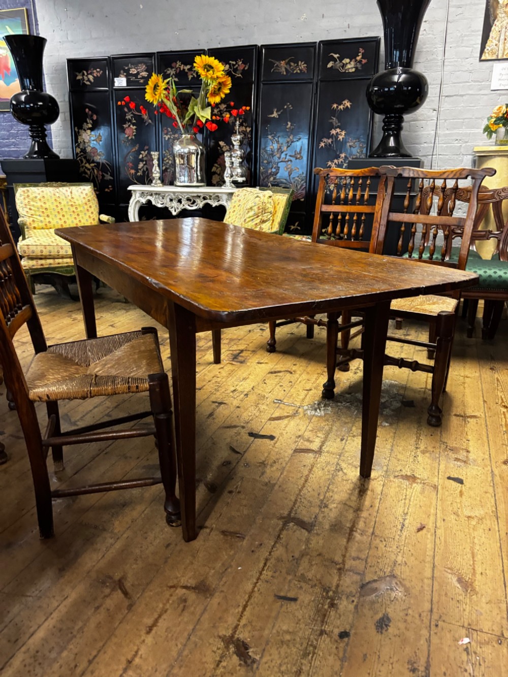 A late 19th-century rectangular fruitwood farmhouse dining table featuring a three-plank top and four square tapered legs. View II