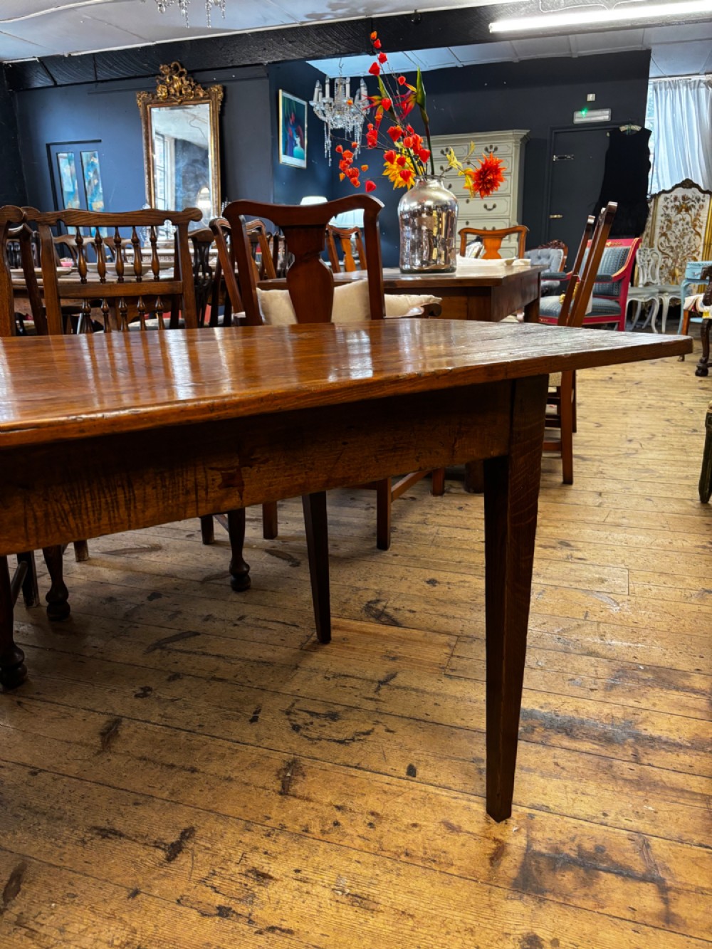A late 19th-century rectangular fruitwood farmhouse dining table featuring a three-plank top and four square tapered legs. View III
