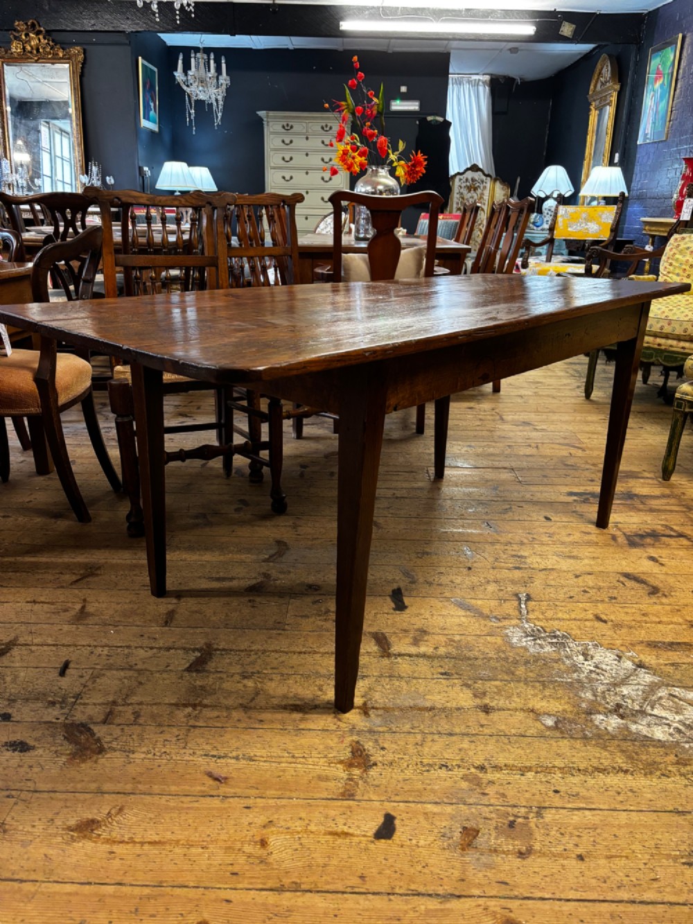 A late 19th-century rectangular fruitwood farmhouse dining table featuring a three-plank top and four square tapered legs. View IV