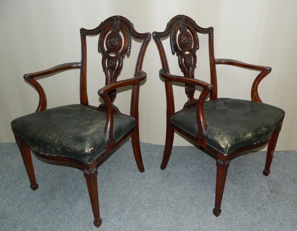 A set of eight dark mahogany dining chairs including six side chairs and two carver armchairs with intricate carved splat backs and buttoned dark leather seats. View III