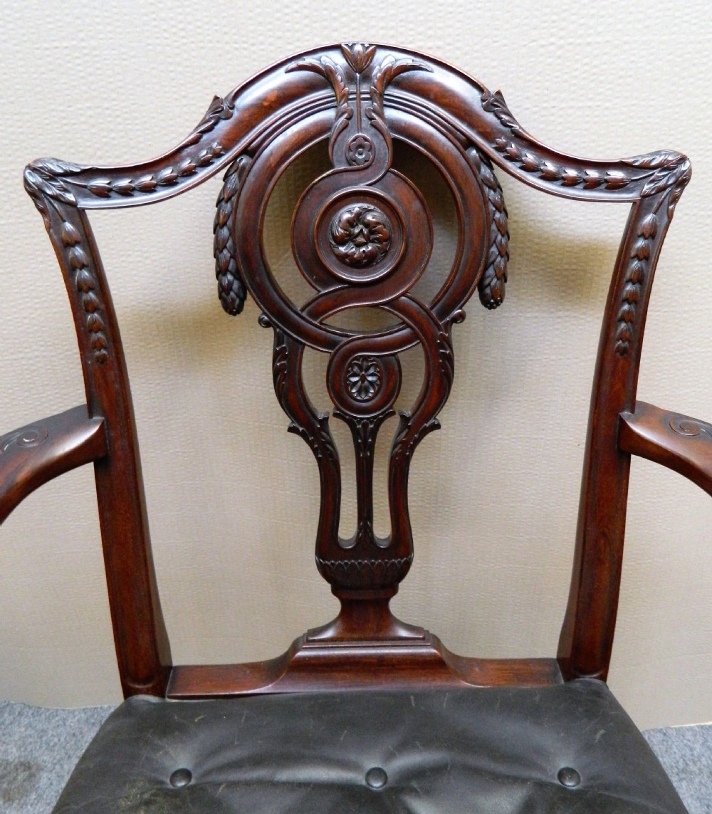A set of eight dark mahogany dining chairs including six side chairs and two carver armchairs with intricate carved splat backs and buttoned dark leather seats. View IV
