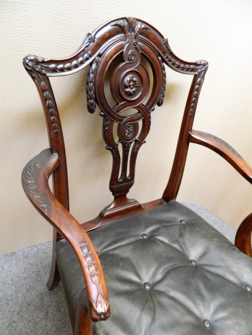 A set of eight dark mahogany dining chairs including six side chairs and two carver armchairs with intricate carved splat backs and buttoned dark leather seats. View VI