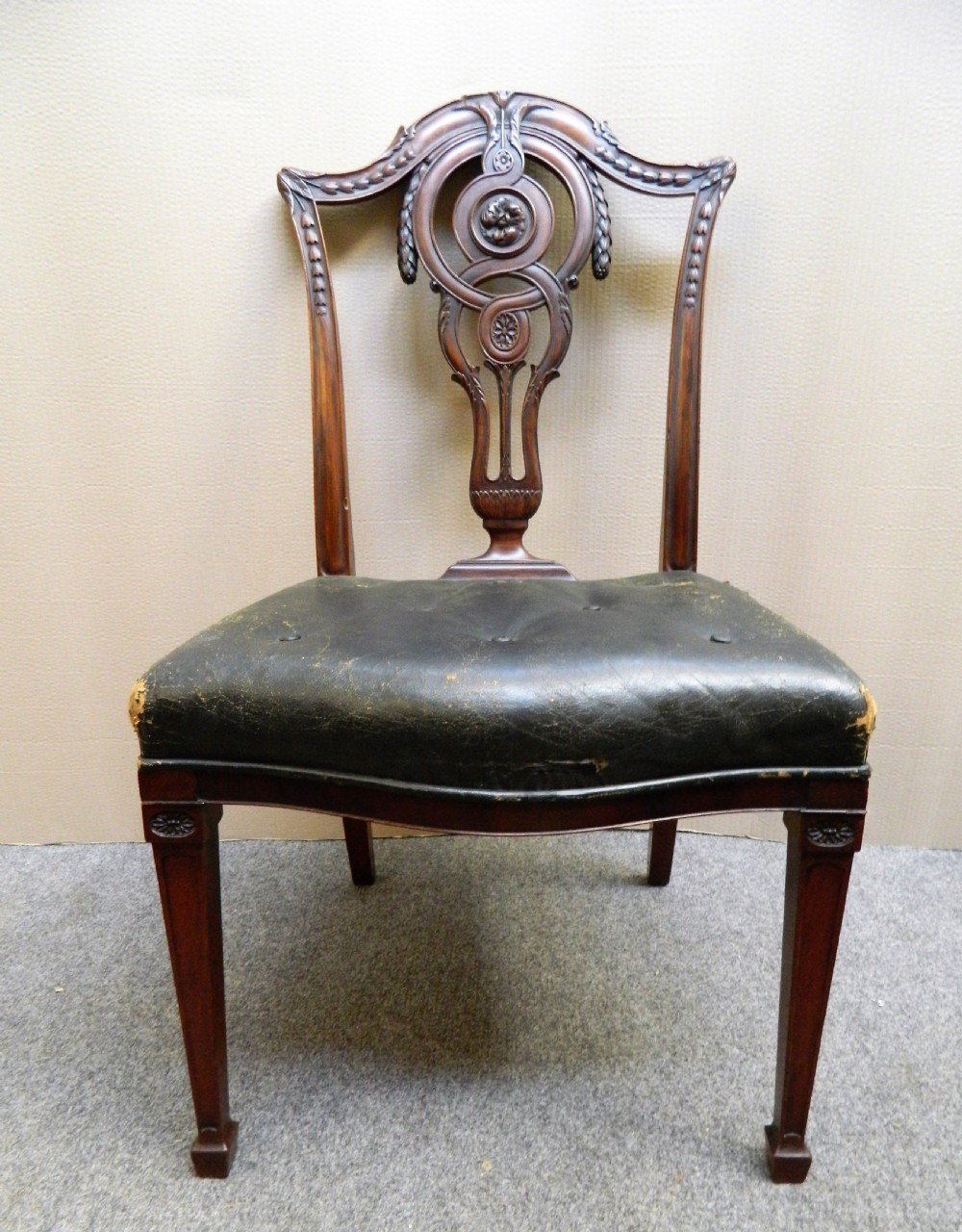 A set of eight dark mahogany dining chairs including six side chairs and two carver armchairs with intricate carved splat backs and buttoned dark leather seats. View VII