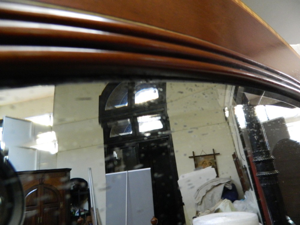 A large rectangular mirror with a gentle arched top set within a wide mahogany wood frame featuring contrasting satinwood crossbanding. View V