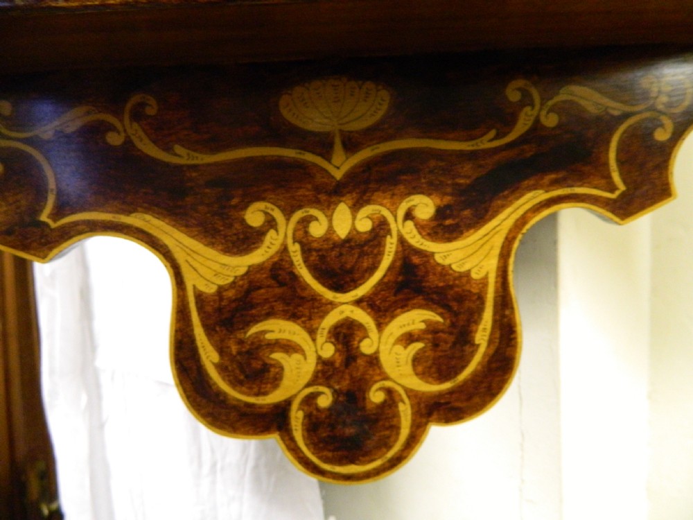 A dark wood hanging wall cabinet decorated with intricate floral light-wood marquetry inlay, featuring a single door and a shaped decorative gallery. View III