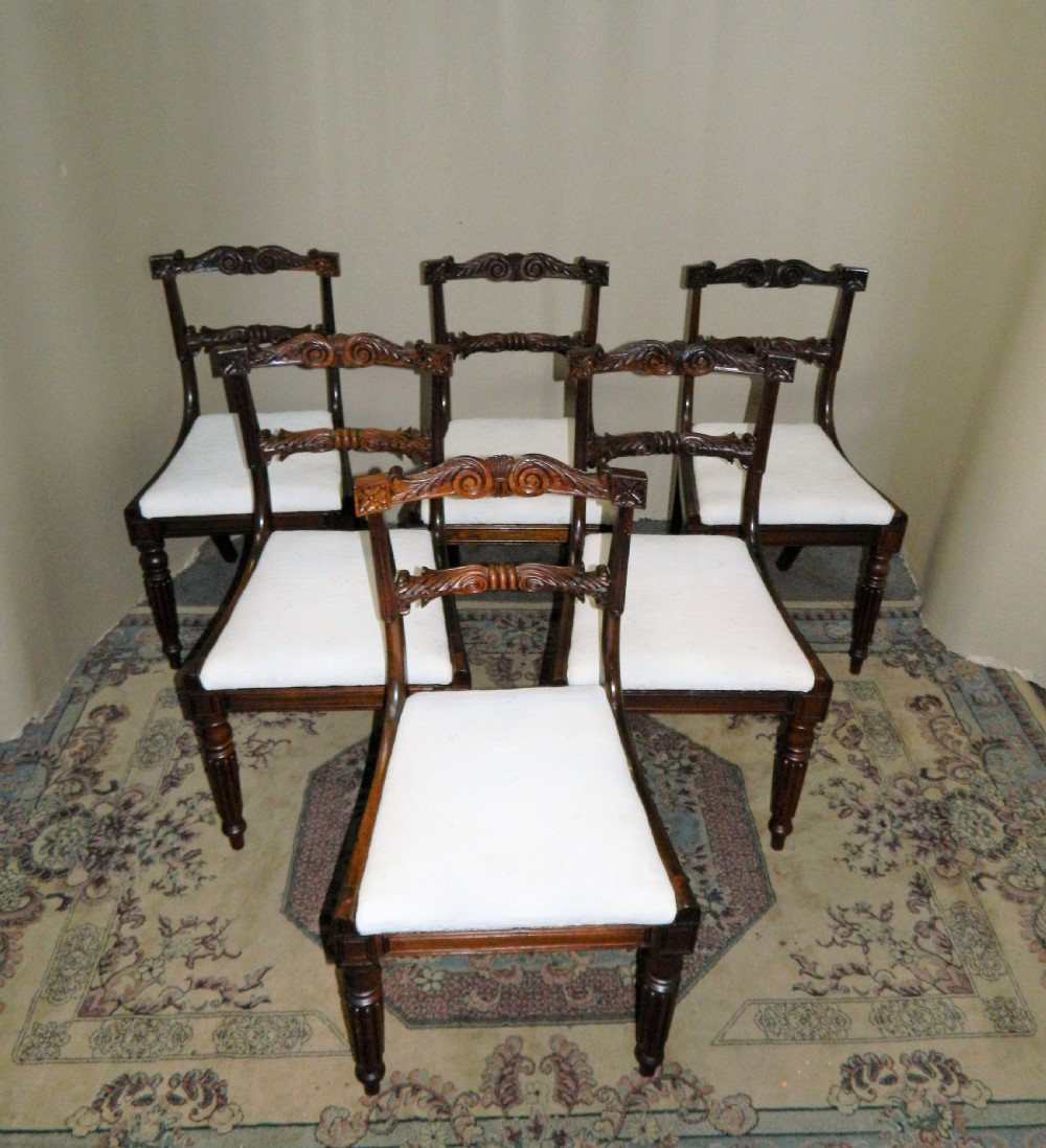 Set of six antique William IV rosewood dining chairs featuring carved scroll top rails and cream upholstered seats. View II