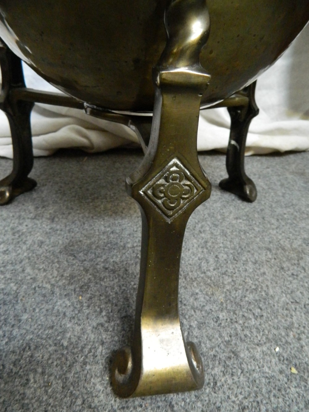 An Arts and Crafts period brass coal bin featuring a domed removable lid, top handle, and three twisted spiral legs on tripod feet. View II