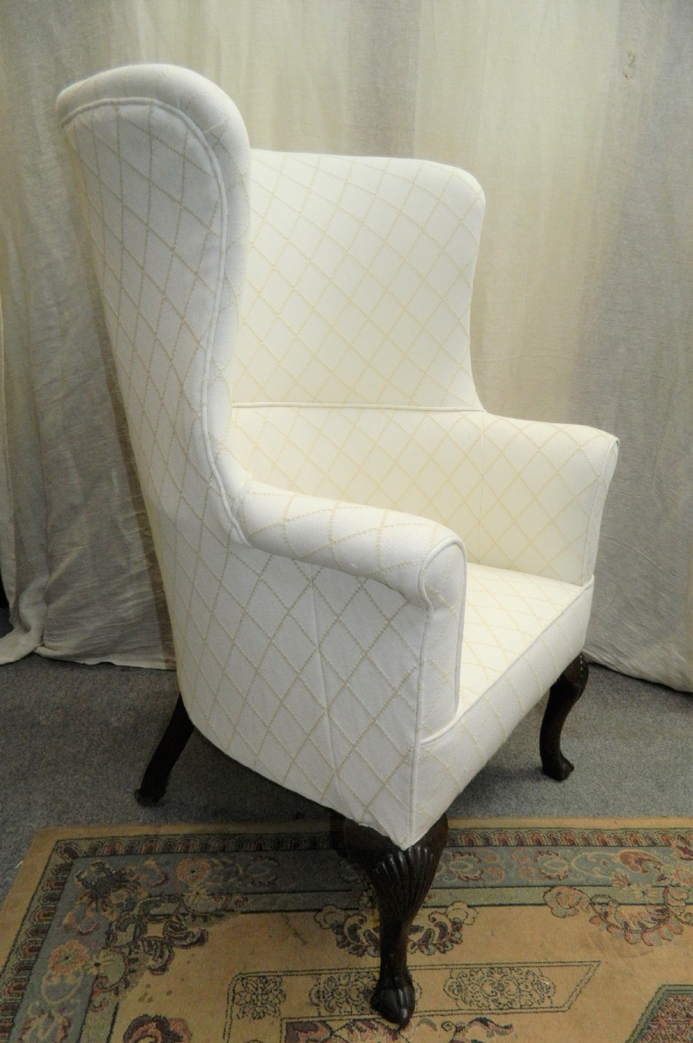A Georgian barrel back armchair upholstered in a cream diamond-patterned fabric, supported by dark mahogany cabriole legs with shell-carved knees and ball and claw feet. View II
