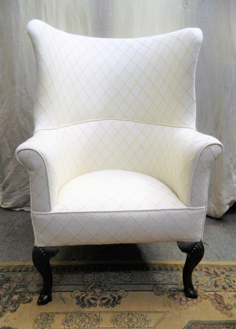 A Georgian barrel back armchair upholstered in a cream diamond-patterned fabric, supported by dark mahogany cabriole legs with shell-carved knees and ball and claw feet. View III