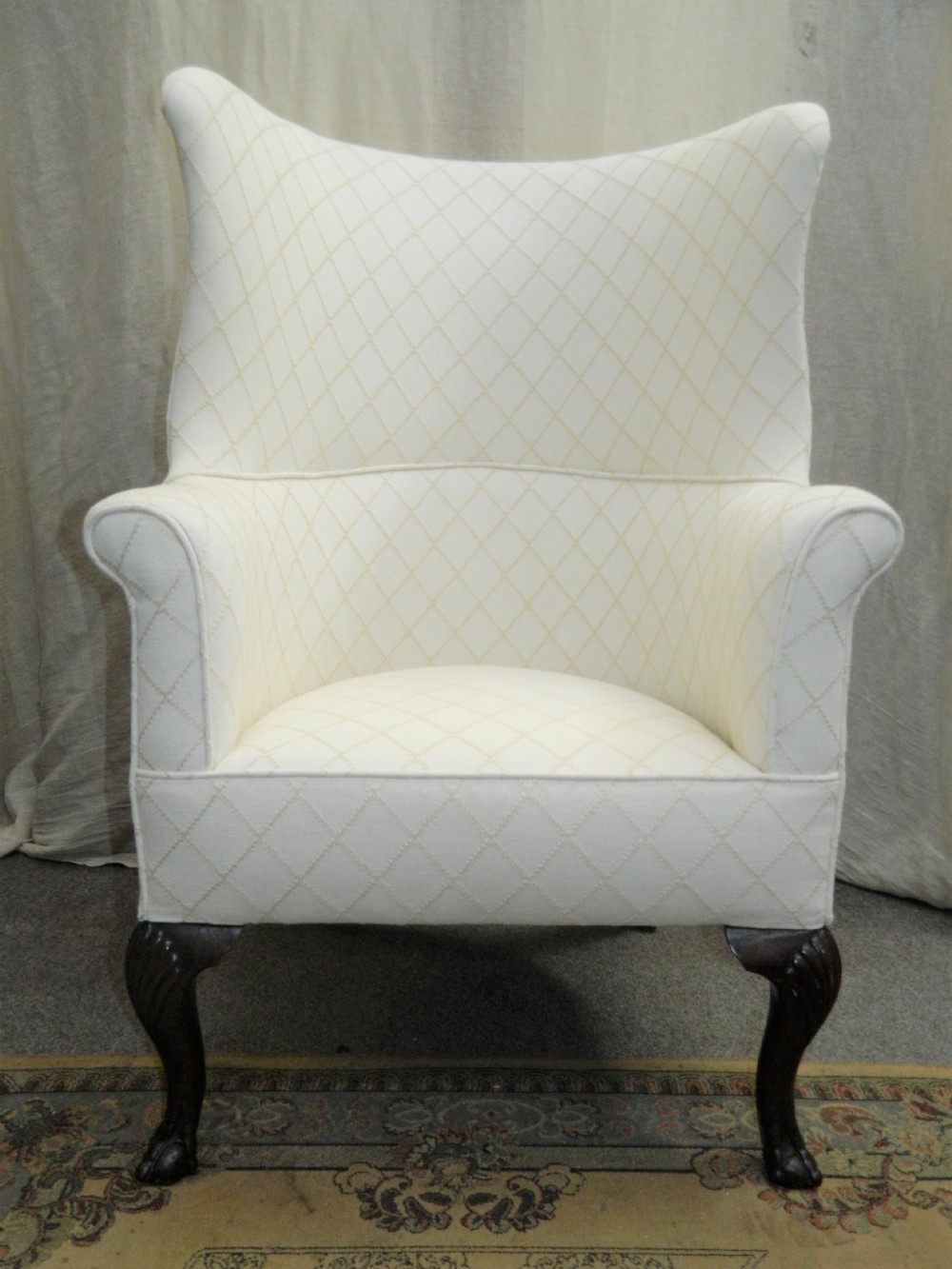 A Georgian barrel back armchair upholstered in a cream diamond-patterned fabric, supported by dark mahogany cabriole legs with shell-carved knees and ball and claw feet. View VII
