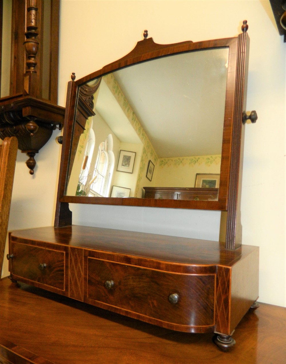 An antique mahogany toilet mirror featuring a swivelling arched glass frame mounted on a base with two inlaid drawers. View III