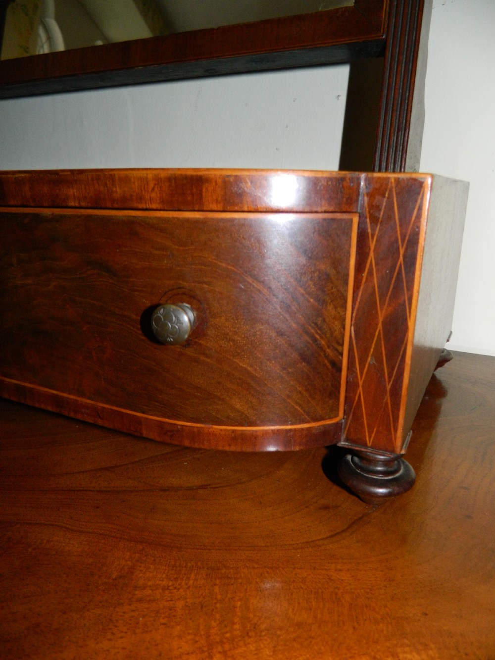 An antique mahogany toilet mirror featuring a swivelling arched glass frame mounted on a base with two inlaid drawers. View V