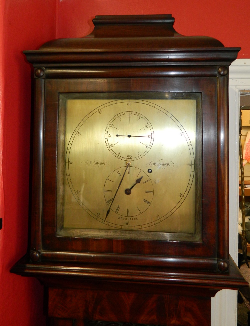 A Victorian dark mahogany regulator longcase clock featuring a silvered regulator dial, glazed trunk door showing the pendulum, and a stepped pediment. View V