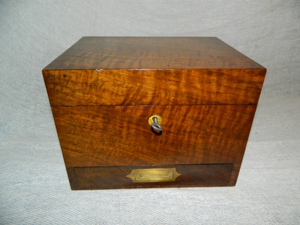 An opened Victorian mahogany apothecary chest displaying rows of glass medicine phials in fitted compartments and a lower drawer containing labelled bottles. View III