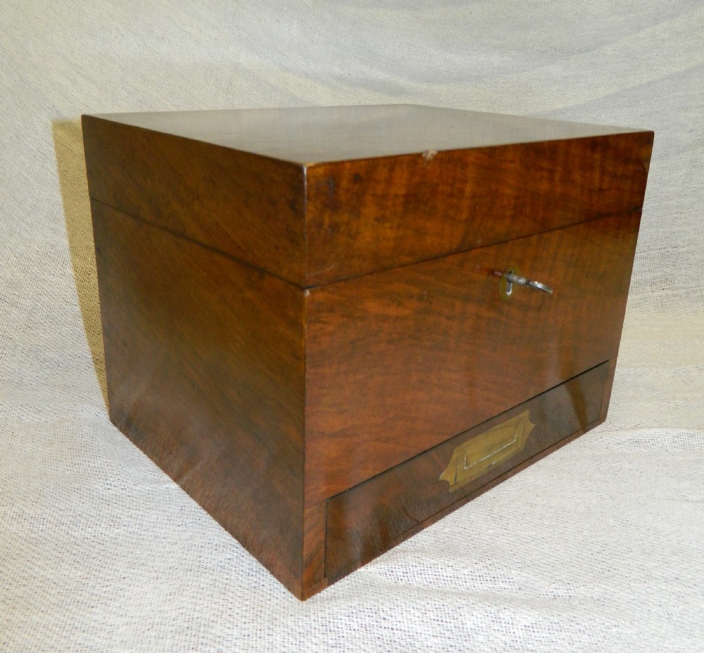 An opened Victorian mahogany apothecary chest displaying rows of glass medicine phials in fitted compartments and a lower drawer containing labelled bottles. View IV