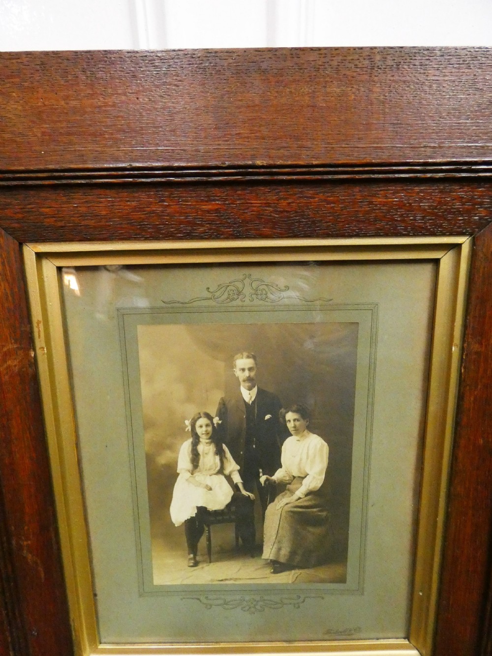 Pair of antique framed sepia family portraits housed within carved dark oak frames featuring inner gold gilt borders. View III