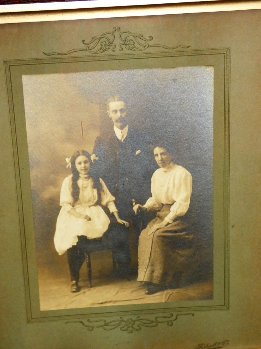 Pair of antique framed sepia family portraits housed within carved dark oak frames featuring inner gold gilt borders. View VIII
