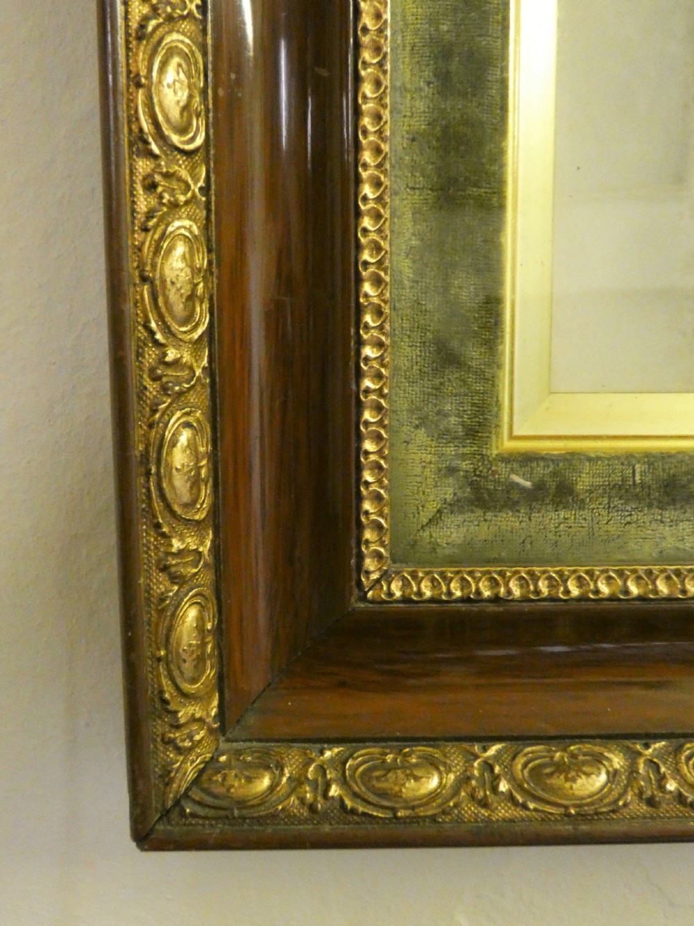 An antique monochrome portrait photograph of a man and woman displayed in a polished mahogany frame with a green velvet mount and decorative gilt slip. View III