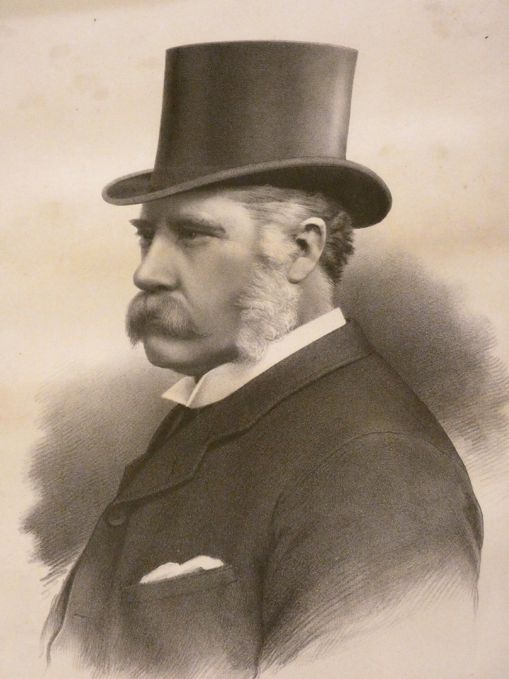 A monochrome antique framed portrait print depicting a Victorian gentleman wearing a top hat, presented in a dark carved wooden frame. View II